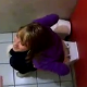 Some girls video record their friend taking a shit on the toilet in a public restroom.